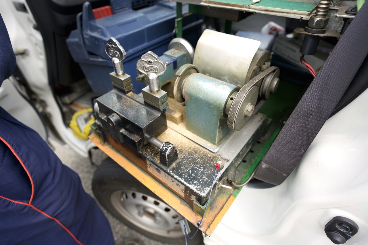 軽トラックの助手席に積んだ車載の鍵製作機。出張先で元の鍵がないとき、錠前の構造から新しい鍵を作るために使う